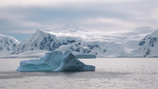海でアイスバーグを溶かす 氷河の巨大なピース 氷河は世界の北の円で溶けている 北極の氷河 南極の山の風景 エコロジー問題 地球温暖化 環境について — ストック動画