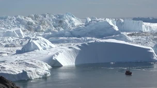 氷の海岸の間の凍った冬の水の風景に浮かぶボート 氷山に囲まれた海での遠足ボート 南極海でのボート 南極半島を探索する — ストック動画