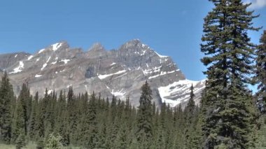 Kanada 'nın doğası. Dağları, ormanları, gölleri ve buzulları olan manzaralar. Kanadalı Rocky Dağları 'ndaki buzul gölü. Titrek bulutlu bir yaz günü boyunca..