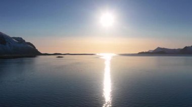 Norveç. Lofoten Adaları. Hava görüntüsü. Deniz suyuna yansıyan beyaz karla kaplı dağlık kayalık tepelerin nefes kesici kuş bakışı görüntüsü. Kışın Lofoten 'in nefes kesici panoramik fiyortları.