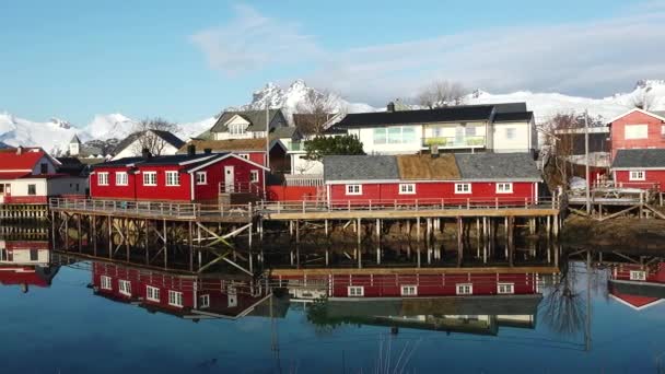 ロフテン諸島の赤い木製のロルブキャビン 伝統的な漁村は 雪の周辺に赤いロルブハウスを持っています 静かな風景が水に美しく映し出されています ノルウェー — ストック動画