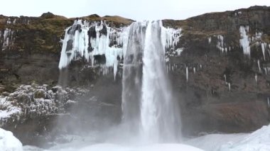İzlanda manzarası, kışın donmuş şelale, su ve buzun büyülü bir yeri, saf turkuaz su, dev bir akıntısı olan buzul nehri..