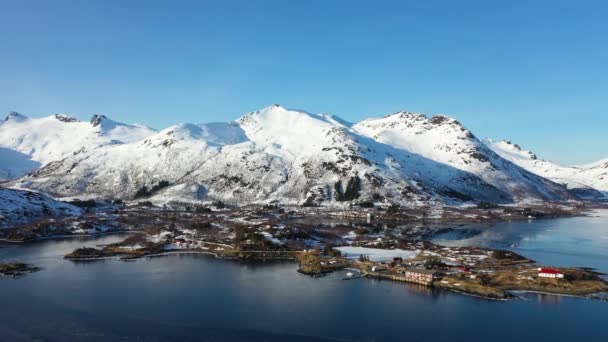 美しいロフテン諸島の冬の風景を眺める空中パノラマドローンビュー ノルウェーのロフォテン諸島 雪に覆われた山々に囲まれたフィヨルドの美しい自然景観 — ストック動画