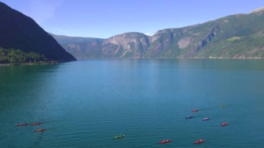 Etkileyici yolculuklar. Norveçli Fjord Sunset Cruise. Karlı dağda sinematik pembe gün batımı. Norveç kutup denizinin karla kaplı fiyortlarla çevrili manzarası. Seyahat kavramı.