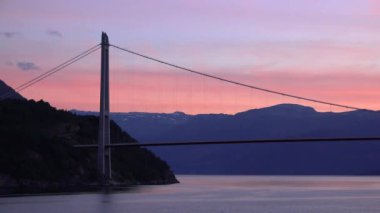 Etkileyici yolculuklar. Norveçli Fjord Sunset Cruise. Karlı dağda sinematik pembe gün batımı. Norveç kutup denizinin karla kaplı fiyortlarla çevrili manzarası. Seyahat kavramı.