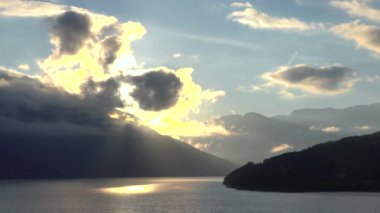 Etkileyici yolculuklar. Norveçli Fjord Sunset Cruise. Karlı dağda sinematik pembe gün batımı. Norveç kutup denizinin karla kaplı fiyortlarla çevrili manzarası. Seyahat kavramı.