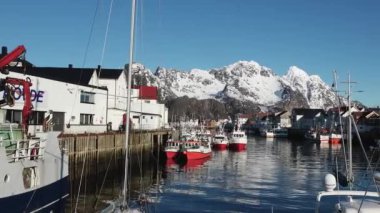 Kışın Norveç denizinde balıkçı teknesi. Lofoten Adaları kış manzarası. Limanda ve denizde geleneksel balıkçı tekneleri var. Soğuk güneşli bir gün, Norveç, İskandinavya, Kuzey Avrupa.