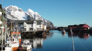 Kışın Norveç denizinde balıkçı teknesi. Lofoten Adaları kış manzarası. Limanda ve denizde geleneksel balıkçı tekneleri var. Soğuk güneşli bir gün, Norveç, İskandinavya, Kuzey Avrupa.