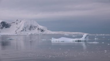 Kış manzarası. Karla kaplı dağlar ve çevrede bir körfez. Güzel doğa. Norveç. Lofoten adaları. İskandinavya, fiyortlar.