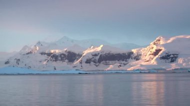 Kış manzarası. Karla kaplı dağlar ve çevrede bir körfez. Güzel doğa. Norveç. Lofoten adaları. İskandinavya, fiyortlar.