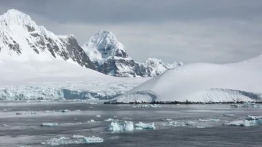 Kış manzarası. Karla kaplı dağlar ve çevrede bir körfez. Güzel doğa. Norveç. Lofoten adaları. İskandinavya, fiyortlar.