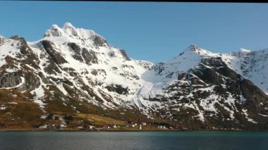 Kış manzarası. Karla kaplı dağlar ve çevrede bir körfez. Güzel doğa. Norveç. Lofoten adaları. İskandinavya, fiyortlar.
