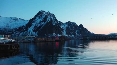 Norveç fiyortlarında renkli günbatımı. Trollfjord 'a git. Lofoten Adaları 'nın karlı dağları. Etkileyici bir dağ boyunca Trollfjord 'a yelken açmak. Yat tahtasından görüntü.