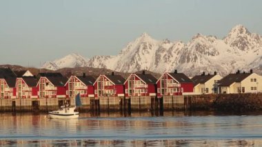 Norveç. Beyaz karla kaplı yüksek dağlı kayalık tepelerin nefes kesici manzarası. Kışın Lofoten fiyortlarının panoramik manzarası, doğanın sakin güzelliği..