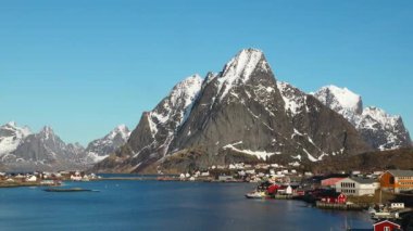Norveç. Beyaz karla kaplı yüksek dağlı kayalık tepelerin nefes kesici manzarası. Kışın Lofoten fiyortlarının panoramik manzarası, doğanın sakin güzelliği..