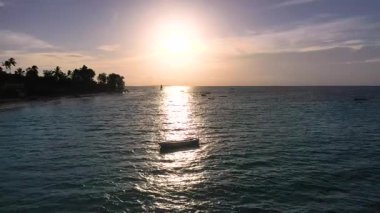 Sakin sular gün batımının canlı renklerini yansıtırken balıkçı tekneleri kıyı köyü yakınlarında huzur içinde dinleniyor. Huzurlu bir manzara alacakaranlıkta doğanın güzelliğini yakalar..