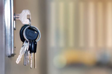 Arka planı bulanık, seçici odaklı, kapı anahtar deliğinde anahtarlık demeti