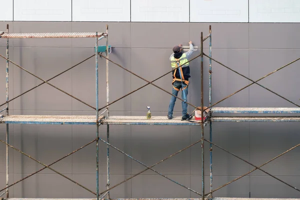 脚手架上的建筑工人准备粉刷房屋外墙 免版税图库照片