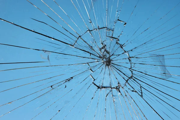 玻璃碎了 玻璃在蓝天背景的意外中破碎了 图库照片