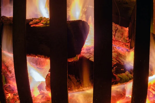 Logs burning in a pit steel basket