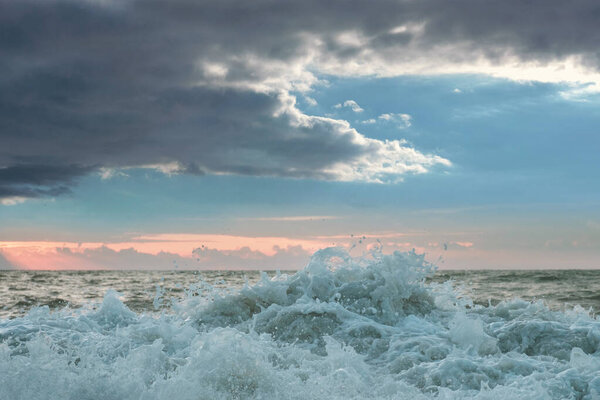 Foamy sea waves splashing, stormy cloudy sky background 