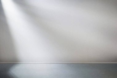 Pencereden gelen güneş ışığı boş oda duvarında ve yerde parlıyor. 