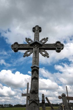 Bulutlu mavi gökyüzü arka planında eski ahşap haç 