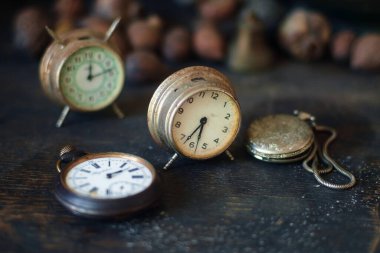 Tahta yüzeyde eski saatler ve cep saatleri, seçici odaklanma