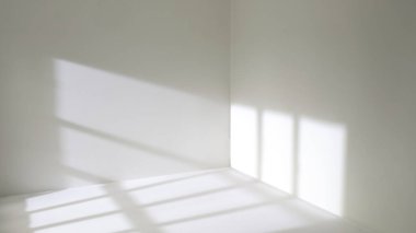 Pencereden gelen güneş ışığı boş oda duvarlarında ve zeminde parlıyor. 