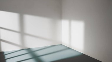 Pencereden gelen güneş ışığı boş oda duvarlarında ve zeminde parlıyor. 