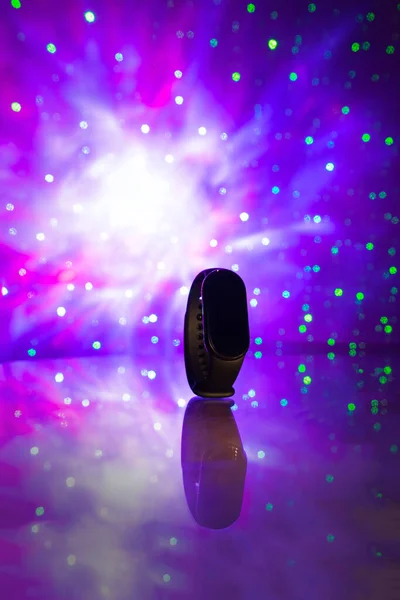 Fitness band on bokeh lights background, new technology concept