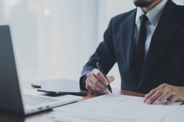 İşadamı imzalı belge, kontrat, iş anlaşması, anlaşma konsepti. İşadamı resmi sözleşme imzalıyor, kalem ile resmi belge ve masadaki dizüstü bilgisayarı kullanıyor.