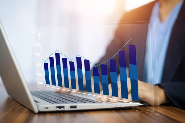 Stock image Businessman using computer analyzes profitability of business graph on visual screen digital and calculates financial data for investments.