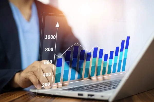 stock image Businessman using computer analyzes profitability of business graph on visual screen digital and calculates financial data for investments.