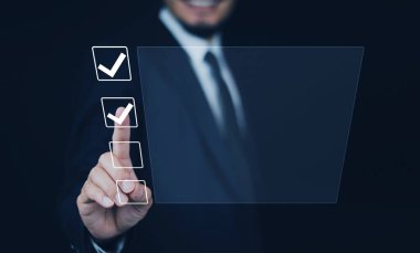 İş dünyasının onaylanması için kalite belge kontrol listesindeki dijital ekran denetim işaretine işadamı dokunuşu.