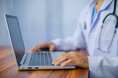 Masada dizüstü bilgisayar kullanan bir doktor.