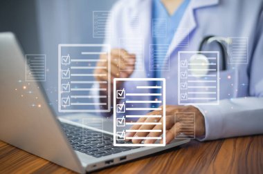 Ofiste dijital belge yönetimi için dizüstü bilgisayar kullanan doktor,