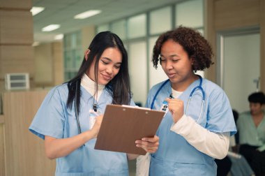 Tıp fakültesi koridorundan konuşan çok ırklı hemşire öğrenci grubu..