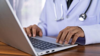 Doktorlar modern teknolojiyi kullanarak tedavi verilerini hastanenin veri depolama sistemine kaydetmek için bilgisayar kullanıyorlar..