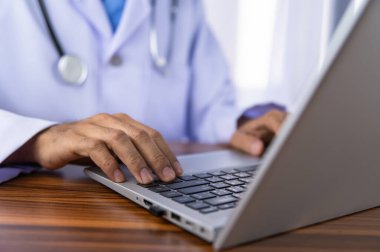 Doktorlar modern teknolojiyi kullanarak tedavi verilerini hastanenin veri depolama sistemine kaydetmek için bilgisayar kullanıyorlar..