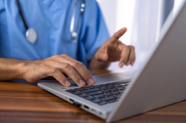 Doktorlar modern teknolojiyi kullanarak tedavi verilerini hastanenin veri depolama sistemine kaydetmek için bilgisayar kullanıyorlar..
