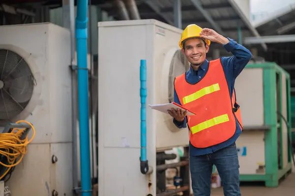 stock image Asian engineer diligently inspects machinery in an industrial factory.Asian workers diligently inspect machinery with focused determination in industrial factories.