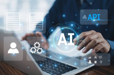 Bir işadamı, Uygulama Programlama Arayüzleri (API), Yapay Zeka (AI) ve mikro ergenleri entegre etmek, işlevsel verimliliği artırmak ve sürüş yeniliklerini geliştirmek için bir bilgisayar kullanır..