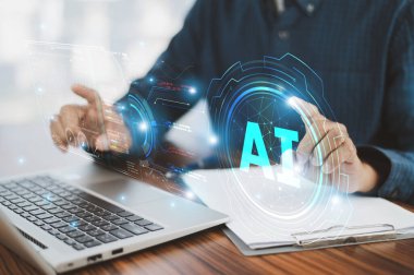 Yapay zekanın modern iş çözümlerine entegrasyonunu sembolize eden yapay zeka teknolojisini gösteren fütüristik dijital arayüzlü bilgisayar laptopu kullanan yakın çekim eli.