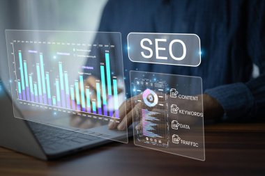 Web sitesi trafiğini, anahtar kelime stratejisini ve içerik planlamasını geliştirmek için SEO performansını dijital araçlar ve veri görselleştirmesi kullanarak analiz eden işadamı.