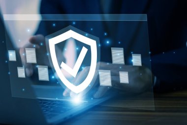 Gelişmiş siber güvenlik kalkanına sahip bir dizüstü bilgisayar üzerinde çalışan iş adamı hassas verilerin korunmasını ve potansiyel tehditlere karşı dijital ortamı güvence altına alıyor..