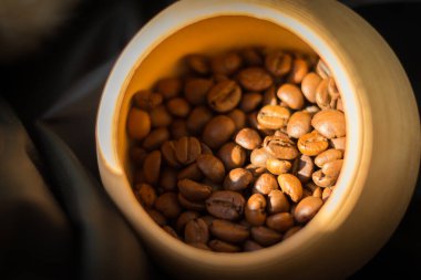 Kil kasede kahve çekirdekleri. Kahverengi kavrulmuş kahve. Kafein içeceği. Kahve dükkanı. Aroma içer. Gün ışığında kahve çekirdekleri. Sabah içkileri. Arap kupası. Aromatik kahvaltı.. 