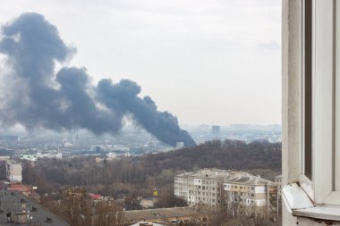 Black smoke from explosion in Kyiv, Ukraine. Russian invasion to Ukraine. Missile attack in Kyiv. Kyiv cityscape, view rom window. War in Ukraine. Russian agression in Ukraine.