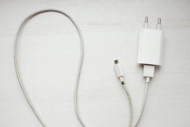 Beyaz arka planda elektrik prizi. Şarj aletinin güç kablosu kopmuş. Kablosu kopmuş. Akıllı telefon cihazı. Cep telefonu kablosu. Elektrik teli tehlikeli durumda..