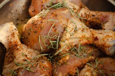 Çiğ tavuk budu ve baharat. Baharatlı tavuk, biberiye ve kırmızı biber. Pişmemiş et. Kasede çiğ et. Ev yapımı barbekü. Et ve bitkiler..